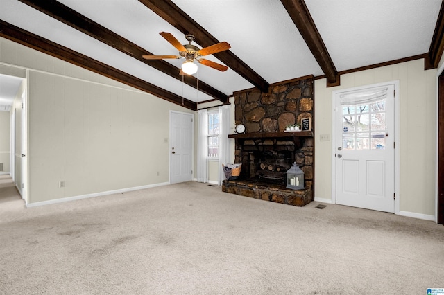 unfurnished living room featuring carpet floors, ceiling fan, a fireplace, and beam ceiling