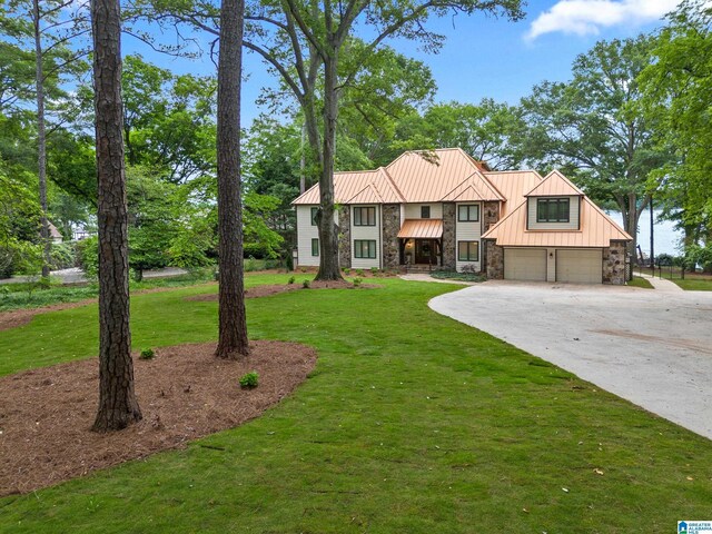 890 River Oaks Dr, Cropwell, AL 35054 - tudor home with stone siding, a garage, a front lawn, driveway, and a standing seam roof