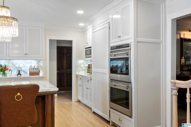 890 River Oaks Dr, Cropwell, AL 35054 - kitchen with light wood-style floors, an inviting chandelier, white cabinetry, and appliances with stainless steel finishes