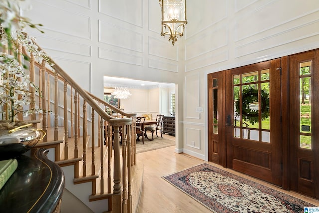890 River Oaks Dr, Cropwell, AL 35054 - foyer with light wood finished floors, an inviting chandelier, a decorative wall, a towering ceiling, and stairway
