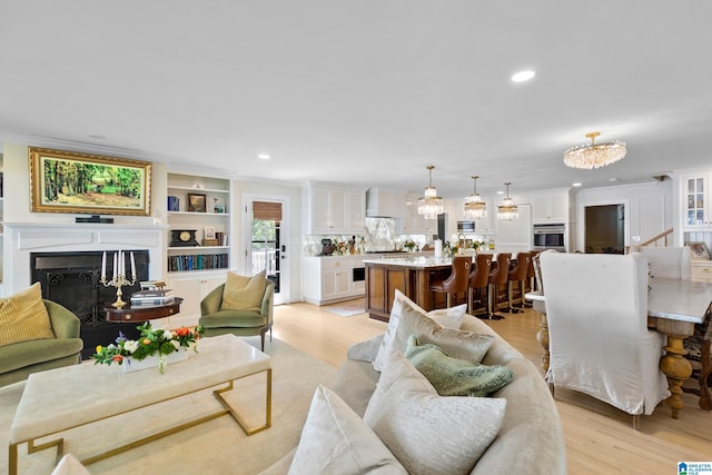 890 River Oaks Dr, Cropwell, AL 35054 - living area with light wood finished floors, ornamental molding, an inviting chandelier, and a fireplace