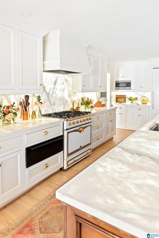 890 River Oaks Dr, Cropwell, AL 35054 - kitchen with premium range hood, stainless steel microwave, a warming drawer, white cabinetry, and white range with gas stovetop