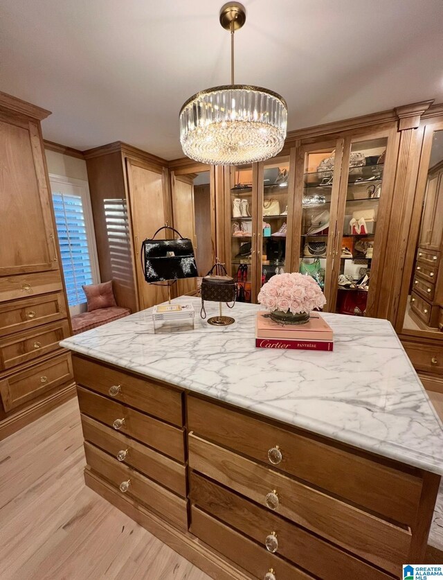 890 River Oaks Dr, Cropwell, AL 35054 - kitchen featuring light wood finished floors, an inviting chandelier, glass insert cabinets, light stone countertops, and decorative light fixtures