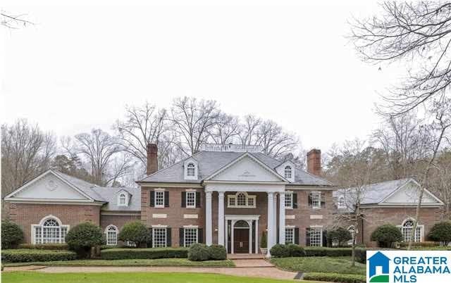 greek revival inspired property featuring a chimney and a front yard