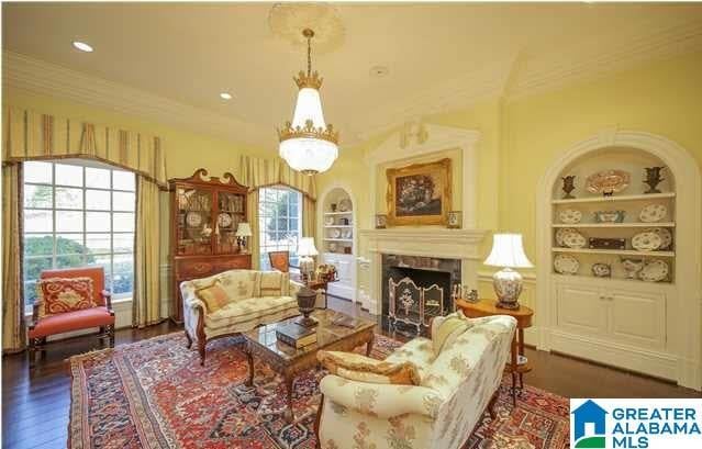 interior space with ornamental molding, dark hardwood / wood-style floors, built in shelves, and an inviting chandelier