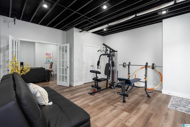 exercise area featuring french doors and wood-type flooring