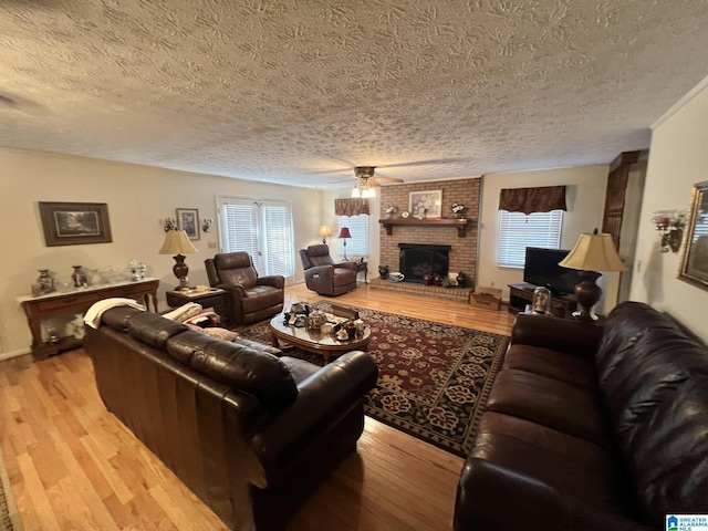 living room with a fireplace, light wood-type flooring, and a wealth of natural light