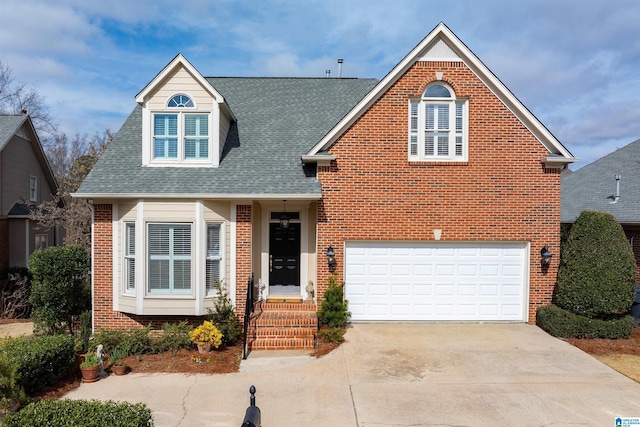 view of front of house with driveway, roof with shingles, a garage, and brick siding