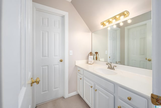 bathroom featuring vaulted ceiling and vanity