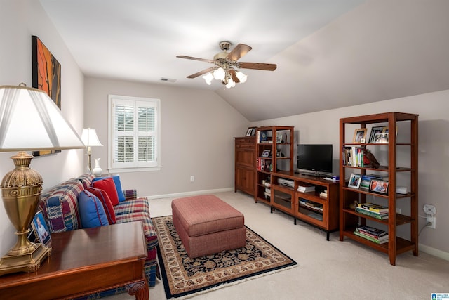 living area featuring vaulted ceiling, baseboards, a ceiling fan, and light colored carpet