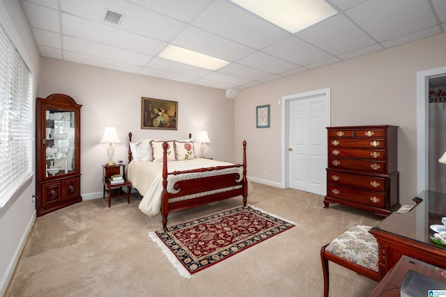 bedroom with light carpet, visible vents, and a paneled ceiling