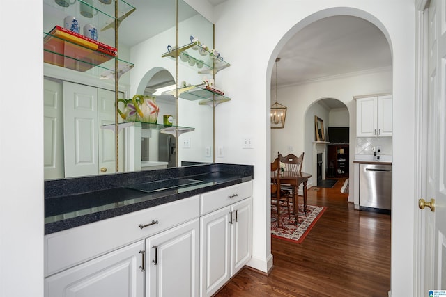 kitchen with tasteful backsplash, white cabinets, dishwasher, dark wood-type flooring, and pendant lighting