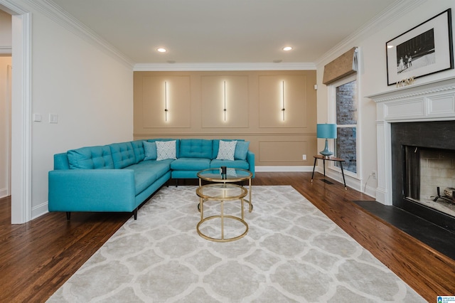 living room featuring dark wood-type flooring, a fireplace with raised hearth, crown molding, and a decorative wall