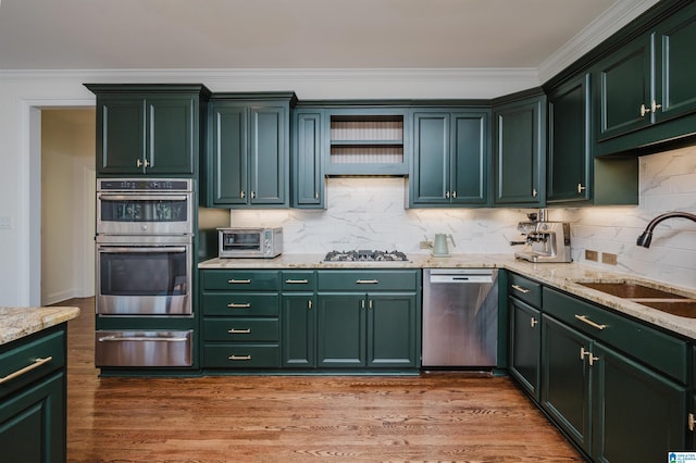 kitchen with stainless steel appliances, dark wood-type flooring, a sink, green cabinets, and a warming drawer