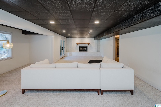 living room with recessed lighting, light carpet, a fireplace, and a paneled ceiling