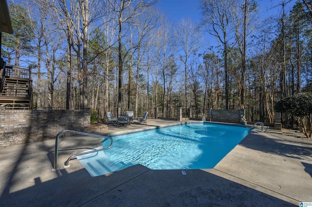 view of pool with a fenced in pool, a patio, fence, and stairs