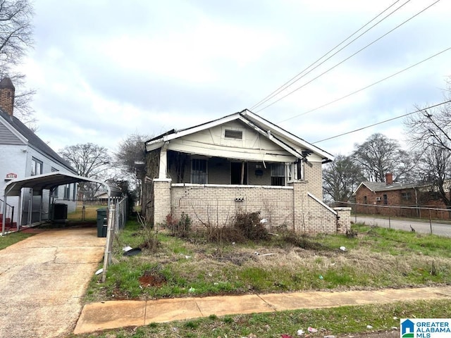 bungalow-style house featuring central AC and a carport