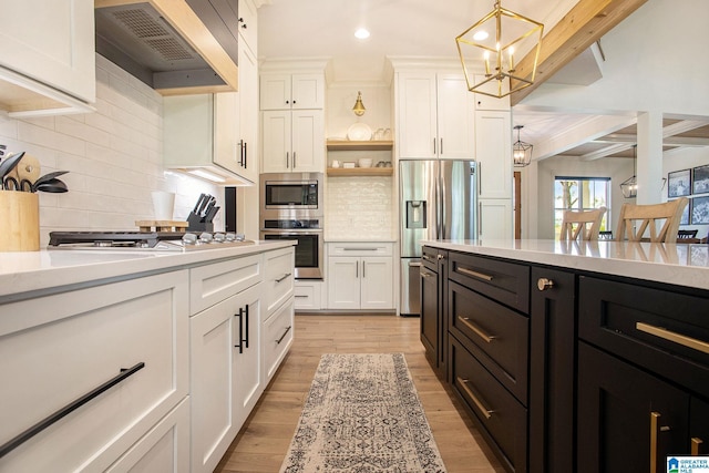 kitchen featuring white cabinetry, light countertops, hanging light fixtures, appliances with stainless steel finishes, and custom exhaust hood