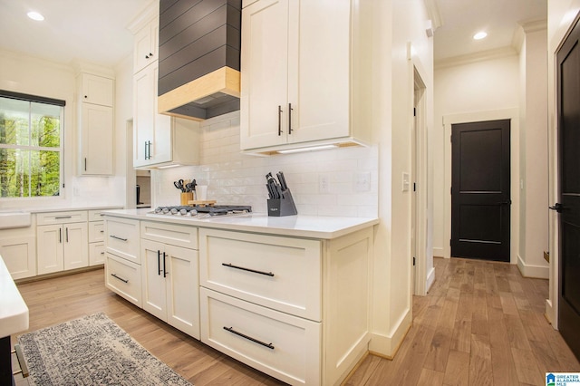 kitchen featuring ornamental molding, light countertops, stainless steel gas cooktop, and decorative backsplash