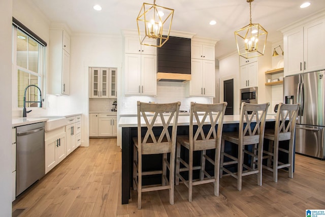 kitchen with appliances with stainless steel finishes, light countertops, and white cabinetry