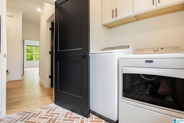 clothes washing area featuring brick floor, cabinet space, ornamental molding, separate washer and dryer, and baseboards