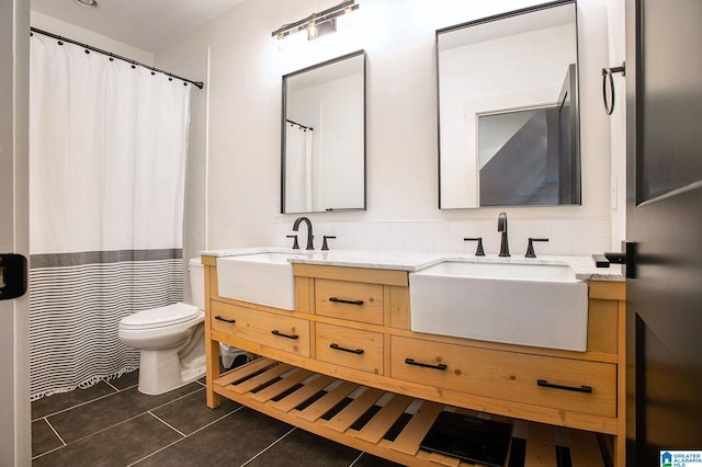 full bath with toilet, tasteful backsplash, a sink, and tile patterned floors