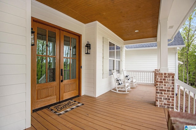 property entrance featuring a shingled roof, french doors, and covered porch