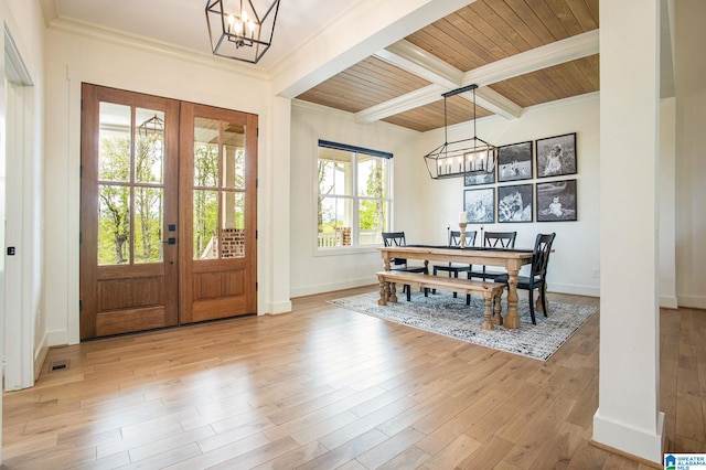 entryway featuring french doors, beam ceiling, a notable chandelier, light wood-style floors, and baseboards