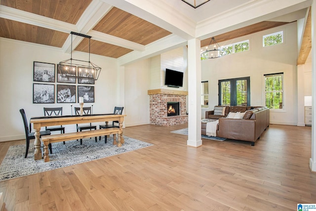 dining area with light wood-type flooring, wood ceiling, a chandelier, and beam ceiling