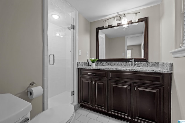 bathroom featuring vanity, a shower with door, and toilet