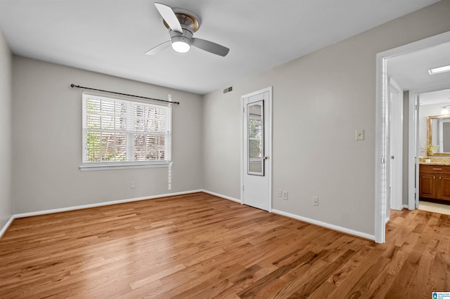 empty room featuring ceiling fan, light hardwood / wood-style floors, and a healthy amount of sunlight