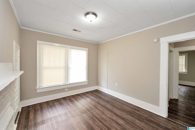 empty room with dark hardwood / wood-style flooring and crown molding