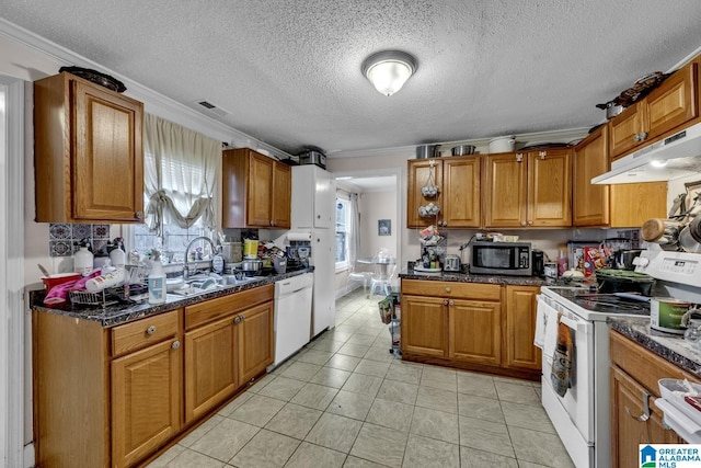 kitchen featuring white appliances, a sink, visible vents, and brown cabinets