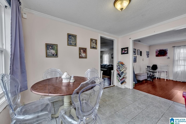 tiled dining space with a textured ceiling and ornamental molding