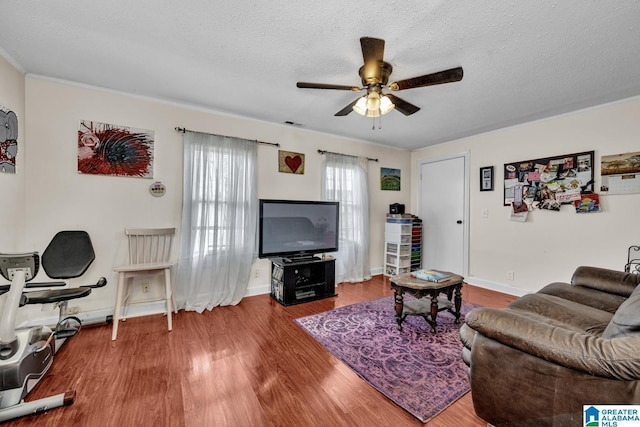 living room featuring baseboards, a textured ceiling, a ceiling fan, and wood finished floors