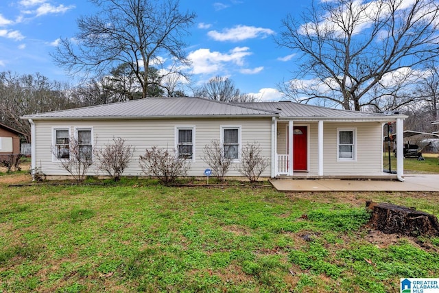 ranch-style house featuring a front yard, covered porch, and metal roof