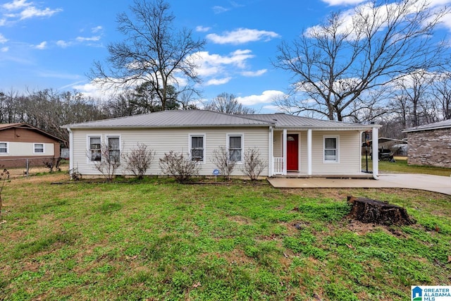 ranch-style home with covered porch, metal roof, and a front yard