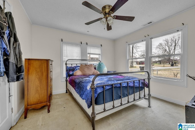 bedroom with baseboards, visible vents, a textured ceiling, and light colored carpet