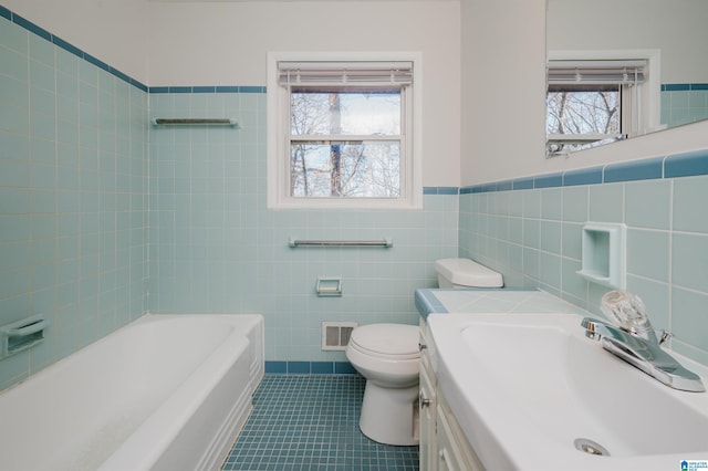 full bath featuring a bathtub, visible vents, plenty of natural light, and tile patterned floors