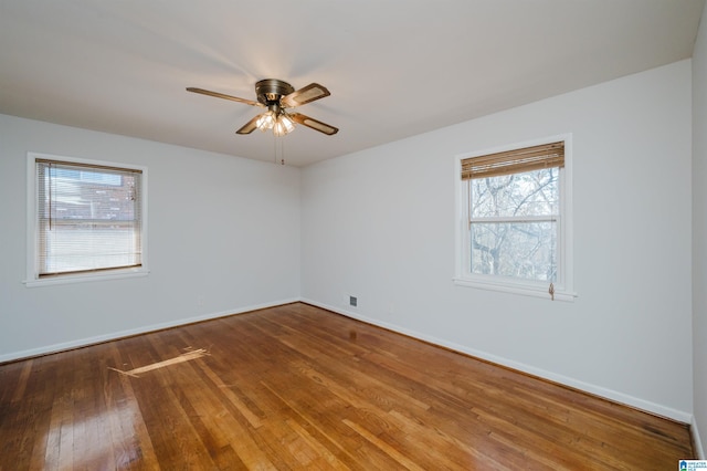 spare room featuring a ceiling fan, baseboards, and wood finished floors