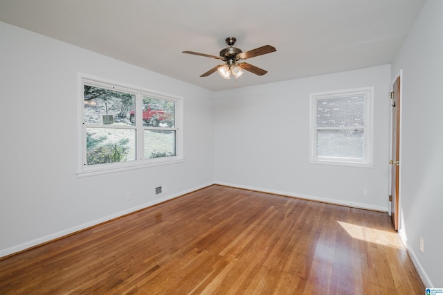 unfurnished room featuring a ceiling fan, baseboards, visible vents, and light wood finished floors