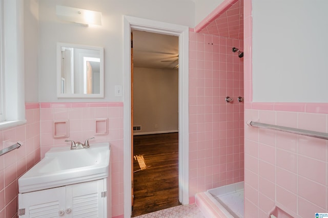 full bathroom featuring a stall shower, wainscoting, tile walls, and vanity