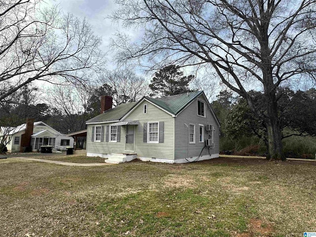 view of front facade with crawl space, a chimney, metal roof, and a front yard