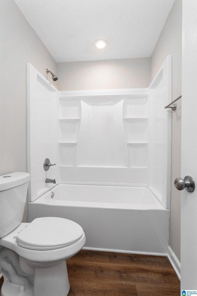 bathroom with toilet, hardwood / wood-style floors, and shower / tub combination