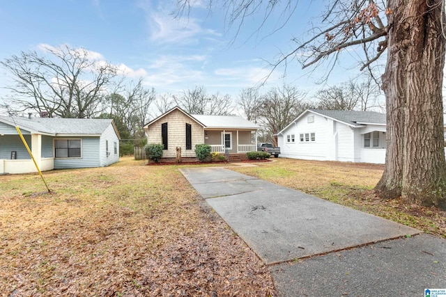 ranch-style house with covered porch and a front yard