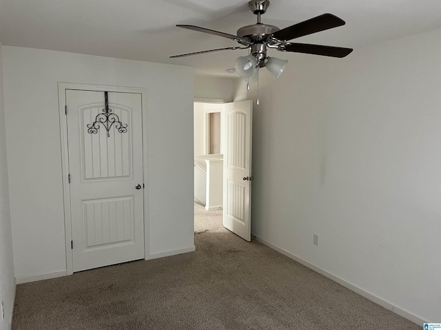 unfurnished bedroom with ceiling fan, carpet, and baseboards