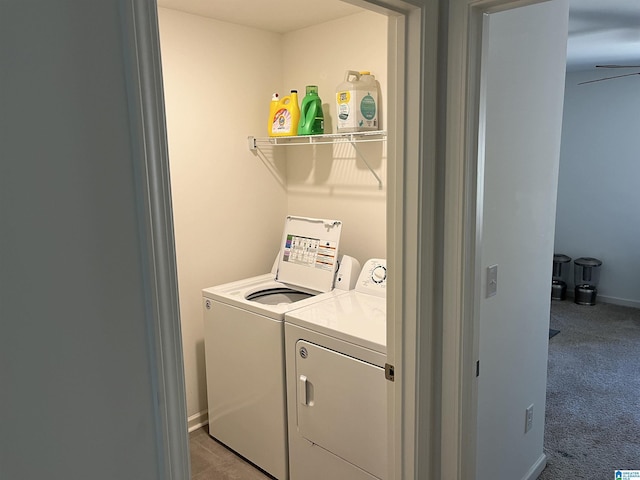 washroom featuring baseboards, laundry area, separate washer and dryer, and light colored carpet