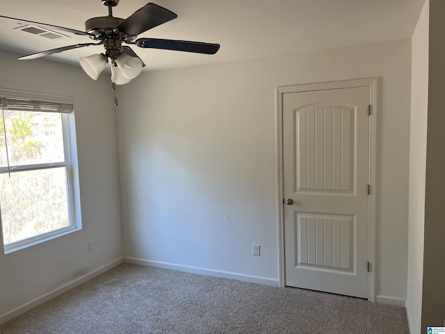 unfurnished room with a ceiling fan, carpet flooring, visible vents, and baseboards