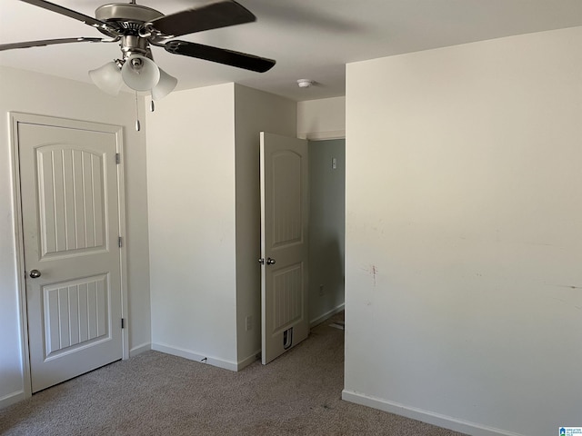 unfurnished bedroom featuring light carpet, ceiling fan, and baseboards