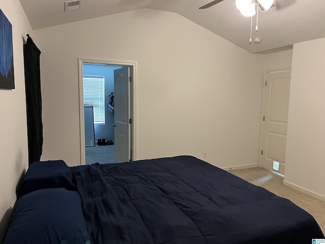 bedroom with baseboards, visible vents, light colored carpet, ceiling fan, and vaulted ceiling